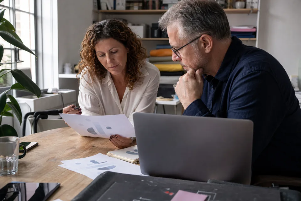 Founder and finance lead reviewing a monthly report together at a table